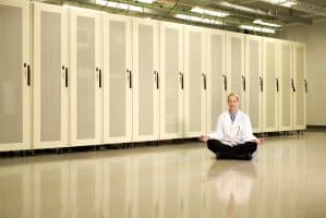 Dama meditando en el cuarto de equipos tecnologicos